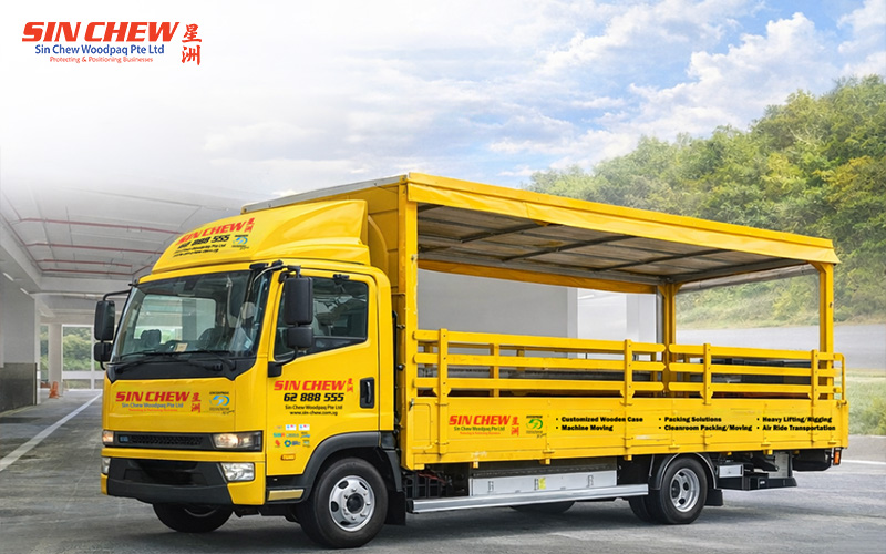 A bright yellow Sin Chew Woodpaq logistics truck