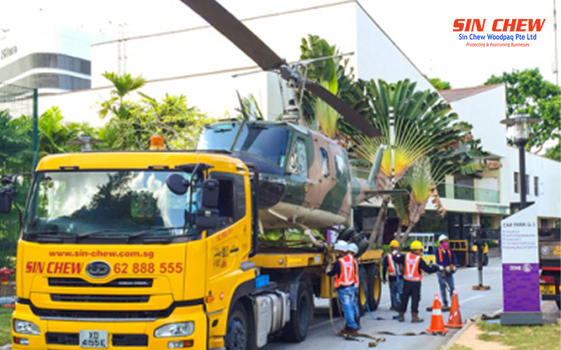 Sin Chew workers securing a helicopter for heavy transport.