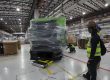 Workers inspecting heavy machinery wrapped for Sin Chew packing.