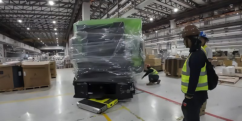 Workers inspecting heavy machinery wrapped for Sin Chew packing. Workers inspecting heavy machinery wrapped for Sin Chew packing.