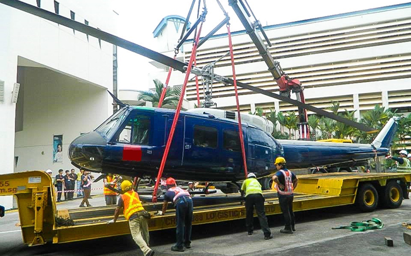 Helicopter-being-loaded-onto-a-heavy-transport-trailer-by-crane
